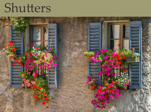 Cheerful blue shutters accented by pink and red flowerboxes